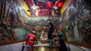 Para sukarelawan membersihkan patung-patung dewa di Kuil Hong San Ko Tee, Surabaya, Jawa Timur, pada Rabu 11 Februari 2026. (JUNI KRISWANTO/AFP)