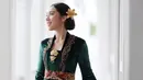 <p>Sedangkan di sini, Laksmi Shari tampil bak putri raja dengan kebaya modern dari bahan beludru hijau, lengkap dengan aksesori bros emas dan belt di bagian pinggang, kain batik sebagai bawahan, dan rambut yang ditata sanggul, serta diberi hiasan bunga sebagai pemanis. Foto: Instagram.</p>