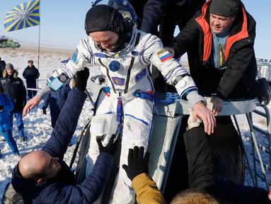 Tim penyelamat antariksa Rusia membantu kosmonot Rusia Sergey Ryazanskiy sesaat setelah pendaratan kapsul Soyuz MS-05 di Kazakhstan (14/12). (AP/ Dmitri Lovetsky/Pool)