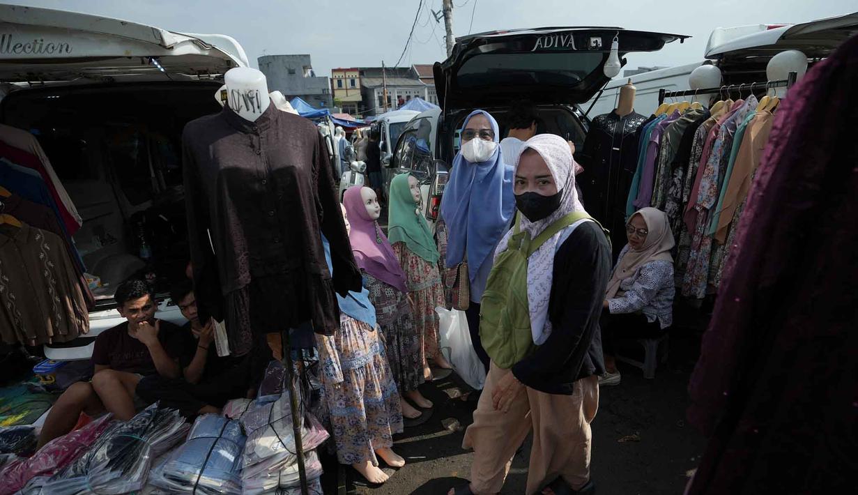 Terletak tidak jauh dari Stasiun KRL Tanah Abang, pasar ini menawarkan beragam busana muslim dengan harga yang relatif terjangkau, baik secara eceran maupun grosiran. Tampak dalam foto, warga berjalan melewati toko-toko pakaian saat mereka bersiap berbelanja untuk keperluan perayaan hari raya Idul Fitri di salah satu pasar musiman di Jakarta, Senin 9 Maret 2026. (AP Photo/Achmad Ibrahim)