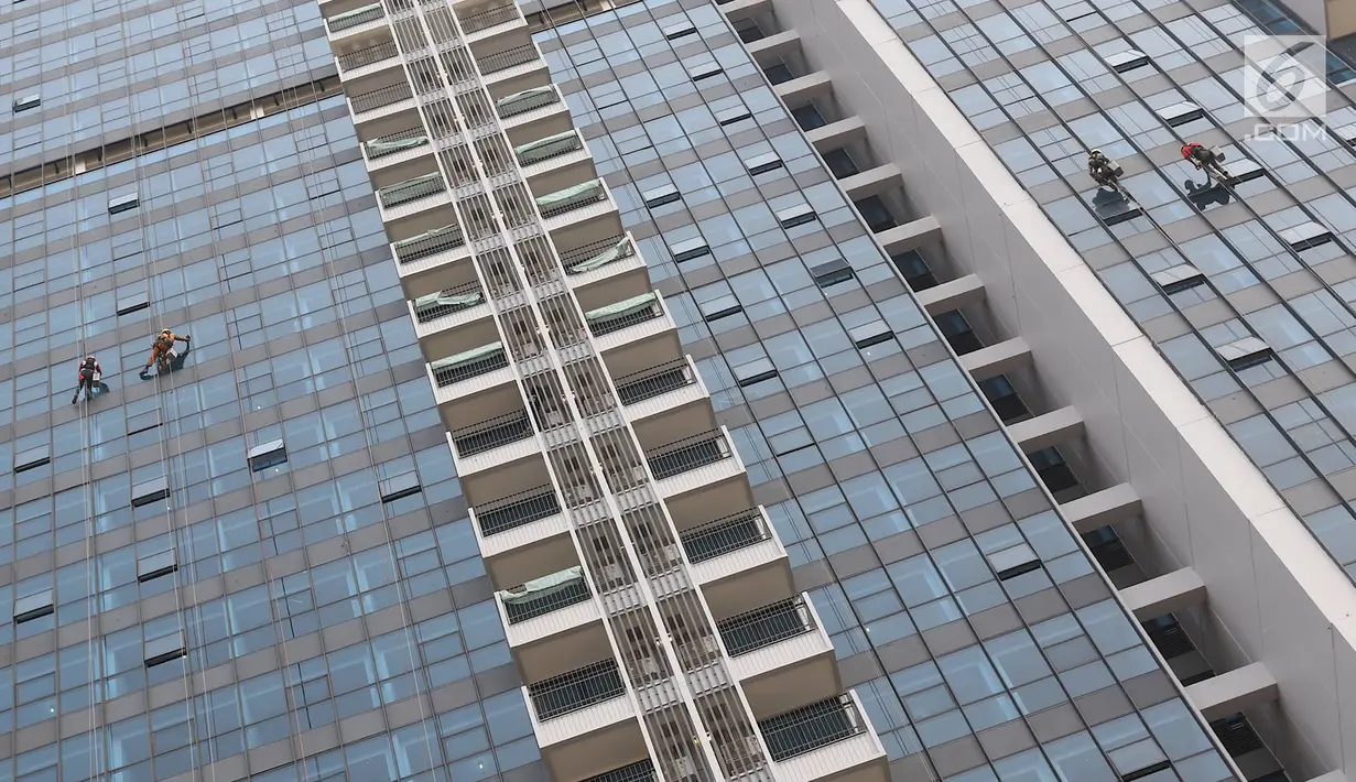 Pekerja membersihkan kaca gedung bertingkat di Jakarta, Kamis (18/10). Kepala Divisi Komunikasi BPJS Ketenagakerjaan Irvansyah Utoh Banja mengatakan, BPJS Ketenagakerjaan menargetkan kepesertaan BPJS Ketenagakerjaan 2018. (Liputan6.com/Immanuel Antonius)