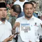 Kuasa hukum Ahmad Dhani, Ramdan Alamsyah menunjukan barang bukti dari media sosial, Jakarta, Rabu (9/11). Ahmad Dhani melaporkan oknum pihak yang menuduhnya menghina Presiden Joko Widodo. (Liputan6.com/Yoppy Renato)