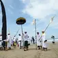 Umat Hindu menyusuri pantai saat menggelar ritual Melasti di Pantai Petitenget, Denpasar, Bali, Senin (4/3). Dalam sejarah, Melasti disimbolkan dengan gunungan sesaji yang dihanyutkan ke laut. (SONNY TUMBELAKA/AFP)