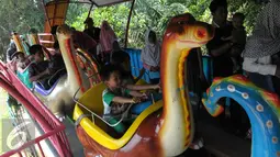 Sejumlah anak menaiki kereta mainan di Ragunan, Jakarta, Jumat (6/5). Tiket masuk yang murah menjadi alasan warga memilih Ragunan menjadi tempat liburan bersama keluarga. (Liputan6.com/Helmi Afandi)