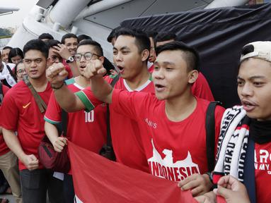 Suporter Timnas Indonesia menyanyikan lagu saat berada di Stadion Nasional, Singapura, Jumat (9/11). Indonesia akan melawan Singapura pada laga Piala AFF 2018. (Bola.com/M. Iqbal Ichsan)