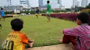 Dua anak melihat kawannya bermain bola di Tugu Tani, Jakarta, Jumat (2/10/2015). Pemprov DKI Jakarta akan menambah ruang publik terpadu ramah anak (RPTRA) sebanyak 150 lokasi dengan menggunakan dana dari program CSR. (Liputan6.com/Faizal Fanani)