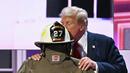 Trump mencium helm Comperatore, mantan Kepala Departemen Pemadam Kebakaran Relawan Kota Buffalo yang tewas ditembak oleh seorang pria bersenjata, Thomas Matthew Crooks, 20 tahun. (Patrick T. Fallon / AFP)