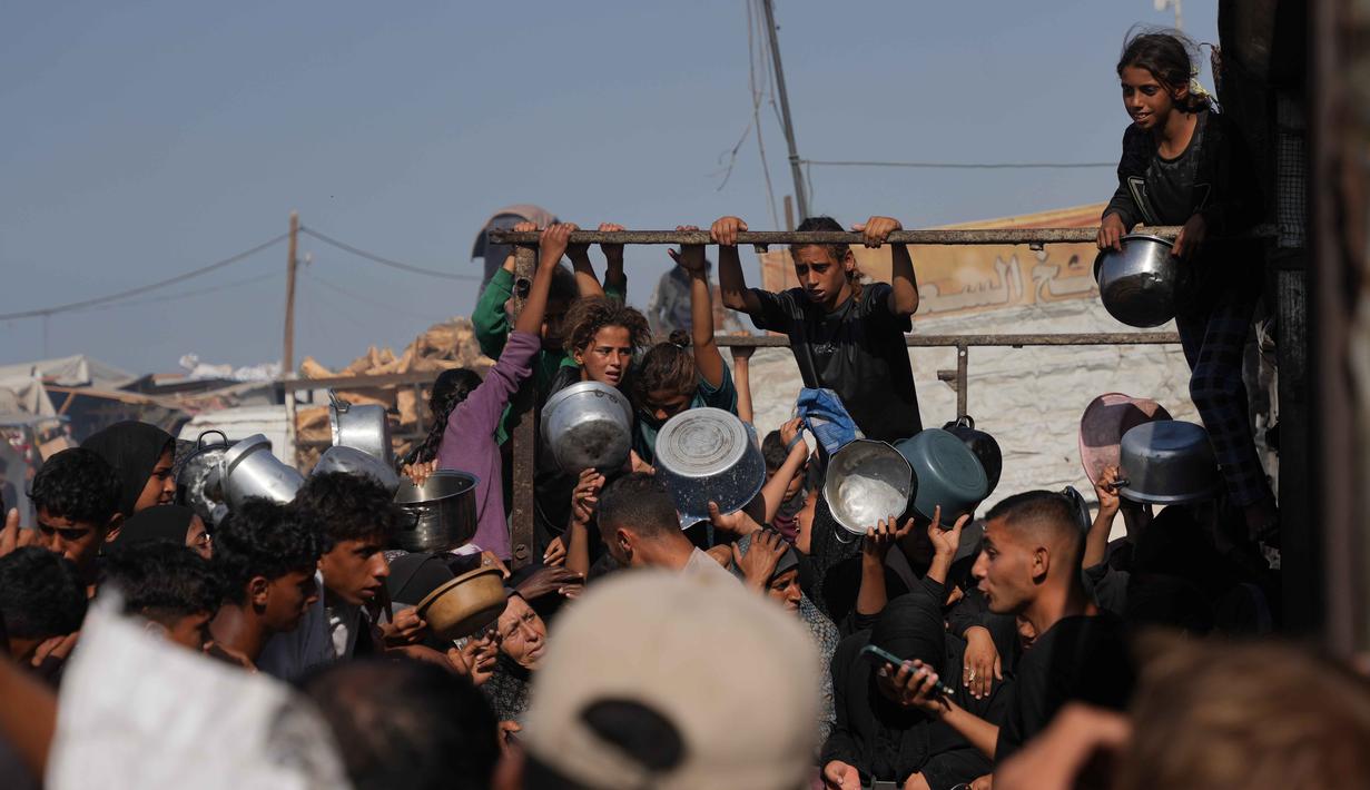 Warga Palestina menunggu bantuan gula dan beras di dapur umum di Khan Younis, Jalur Gaza selatan, Jumat, 31 Oktober 2025. Untuk diketahui, banyak keluarga pengungsi, yang kini tinggal di tenda-tenda darurat, sepenuhnya bergantung pada dapur amal sebagai penyuplai makanan mereka dalam sehari-hari. (AP Photo/Abdel Kareem Hana)