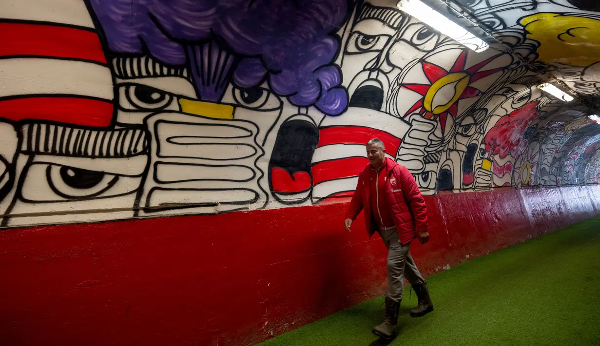 Seorang petugas melewati pintu masuk terowongan terkenal Stadion Rajko Mitic, Beograd, Serbia yang penuh mural dua hari sebelum pertandingan sepak bola Grup G Liga Champions UEFA antara Crvena Zvezda (Red Star Belgrade) dan Manchester City pada 11 Desember 2023 waktu setempat. (AFP/Andrej Isakovic)