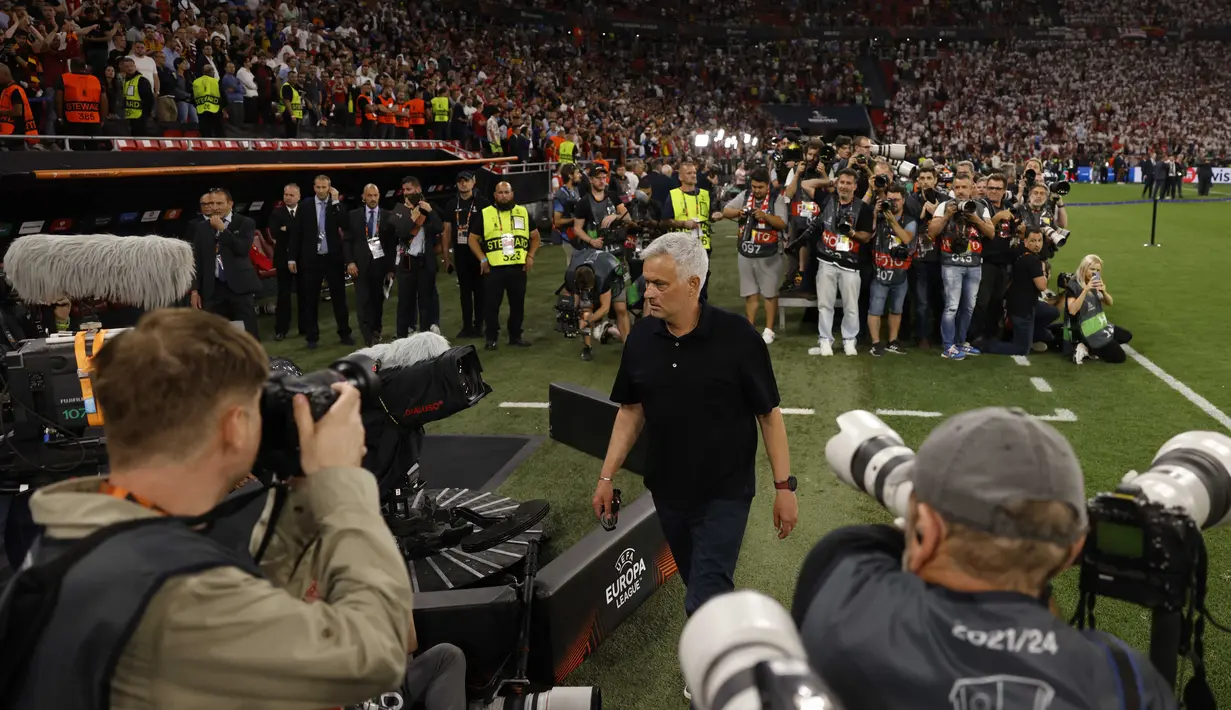 Pelatih AS Roma, Jose Mourinho memegang medali dan berjalan menuju ruang ganti setelah timnya dikalahkan Sevilla lewat babak adu penalti dalam partai final Liga Europa 2022/2023 yang berlangsung di Stadion Puskas Arena, Hungaria, Jumat (01/06/2023) dini hari WIB. (AFP/Odd Andersen)