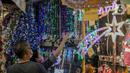 Sejumlah calon pembeli memilih pernak-pernik Natal di Pasar Asemka, Jakarta, Kamis (10/12/2020). Menurut seorang penjual, omset penjualan pernak-pernik bertema Natal turun drastis sekitar 50% dari biasanya karena pandemi Covid-19. (Liputan6.com/Faizal Fanani)