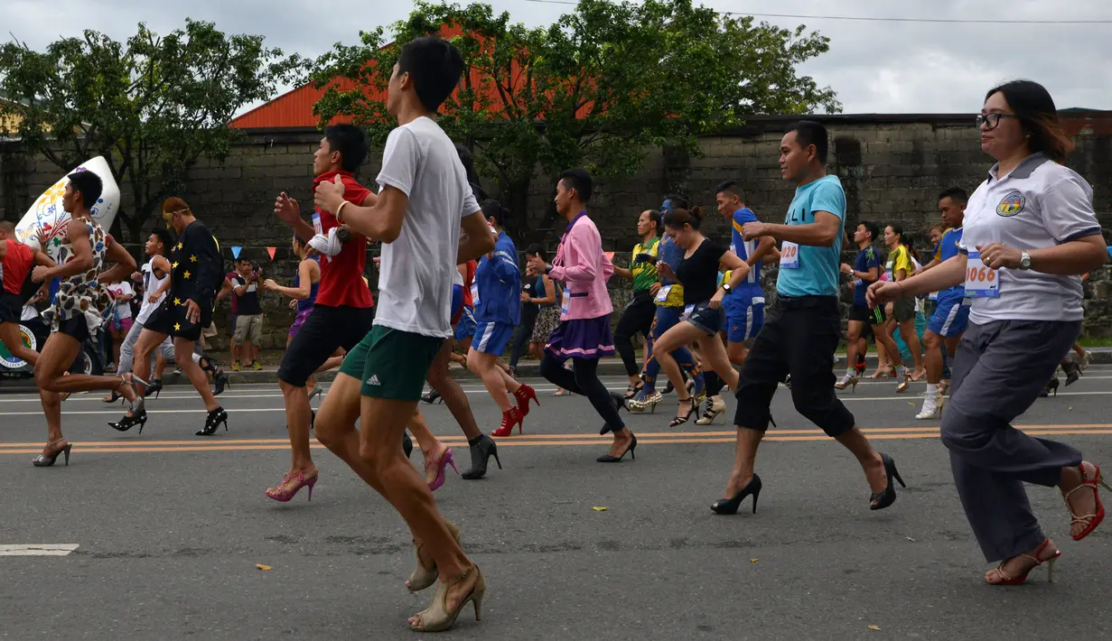 Antusias peserta berlari menggunakan sepatu high heels saat acara "Tour De Takong" di Marikina, Manila, Filipina, 26 November 2016. Balap lari itu bagian dari festival sepatu tahunan di wilayah yang dikenal sebagai ibu kota sepatu. (REUTERS/Ezra Acayan)