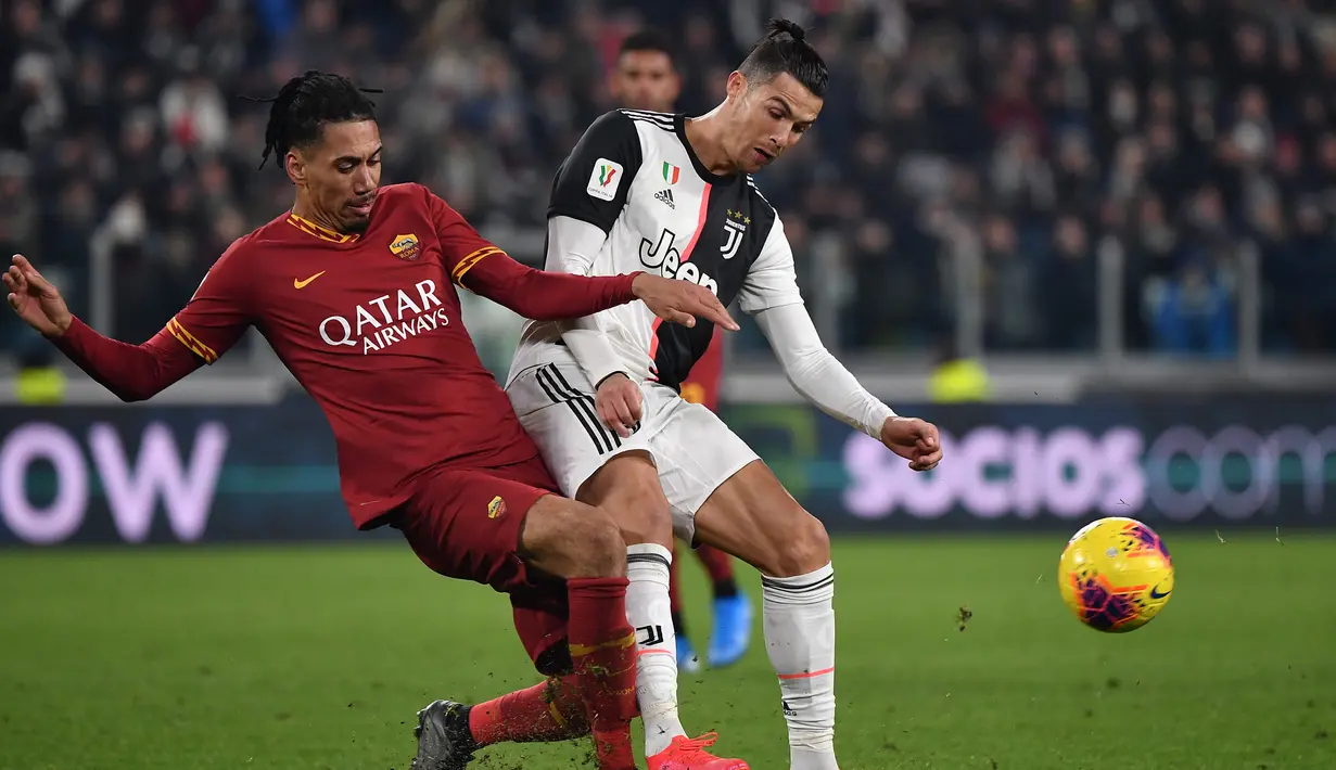 Pemain Juventus Cristiano Ronaldo (kanan) dan pemain AS Roma Chris Smalling berebut bola pada pertandingan Coppa Italia di Turin, Italia, Rabu (22/1/2020). Juventus menggilas AS Roma 3-1 dan berhasil lolos ke semifinal. (Marco Bertorello/AFP)