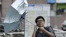 Seorang pria memegang payung menahan hembusan badai tropis Fung-Wong memasuki wilayah Taiwan, (21/9/2014). (REUTERS/Pichi Chuang)