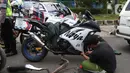Pengendara motor mencopot knalpot bising usai terjaring razia yang digelar Satlantas Polres Metro Depok di Jalan Margonda Raya, Depok, Kamis (18/3/2021). Puluhan motor berknalpot bising yang terjaring razia diwajibkan mengganti knalpot dan diberi sanksi tilang. (Liputan6.com/Helmi Fithriansyah)