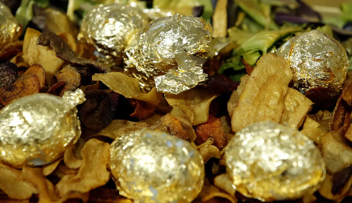 Lembaran emas tipis 24 karat menyelimuti telur rebus yang menjadi hidangan acara makan malam di Paris, Prancis, 28 Maret 2019. Lembaran tipis emas menyelimuti makanan sederhana seperti ayam, telur rebus, dan kue-kue berlapis emas untuk pencuci mulut. (REUTERS/Philippe Wojazer)