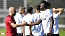 Pelatih Bayer Leverkusen, Peter Bosszduring, berjabat tangan dengan Edmond Tapsoba, usai sesi latihan jelang laga Liga Europa di Leverkusen, Jerman, Selasa (4/8/2020). Bayer Leverkusen akan berhadapan dengan Glasgow Rangers. (AP Photo/Martin Meissner)