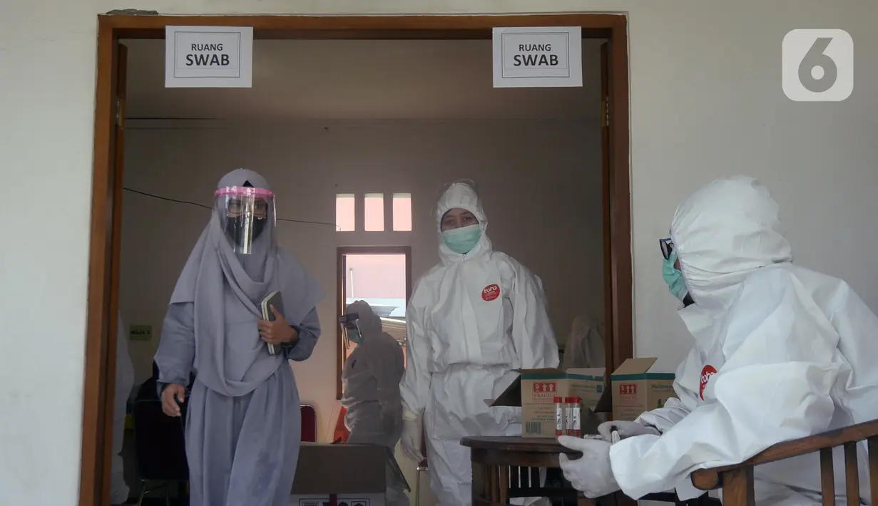 Warga keluar ruangan usai mengikuti swab test di Balai RW 20, Villa Dago, Pamulang, Tangerang Selatan, Banten, Jumat (17/7/2020). Swab test gratis yang dilakukan seiring meningkatnya kasus COVID-19 tersebut diikuti 200 warga dari beberapa RW di Benda Baru. (merdeka.com/Dwi Narwoko)