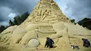 Seniman saat menyelesaikan istana pasir di Landschaftspark di Duisburg, Jerman , (1/9). Seniman dari Duisburg burusaha meraih Guinness Book of World Records dengan membuat istana pasir tertinggi yang pernah ada. (Marcel Kusch / dpa via AP)
