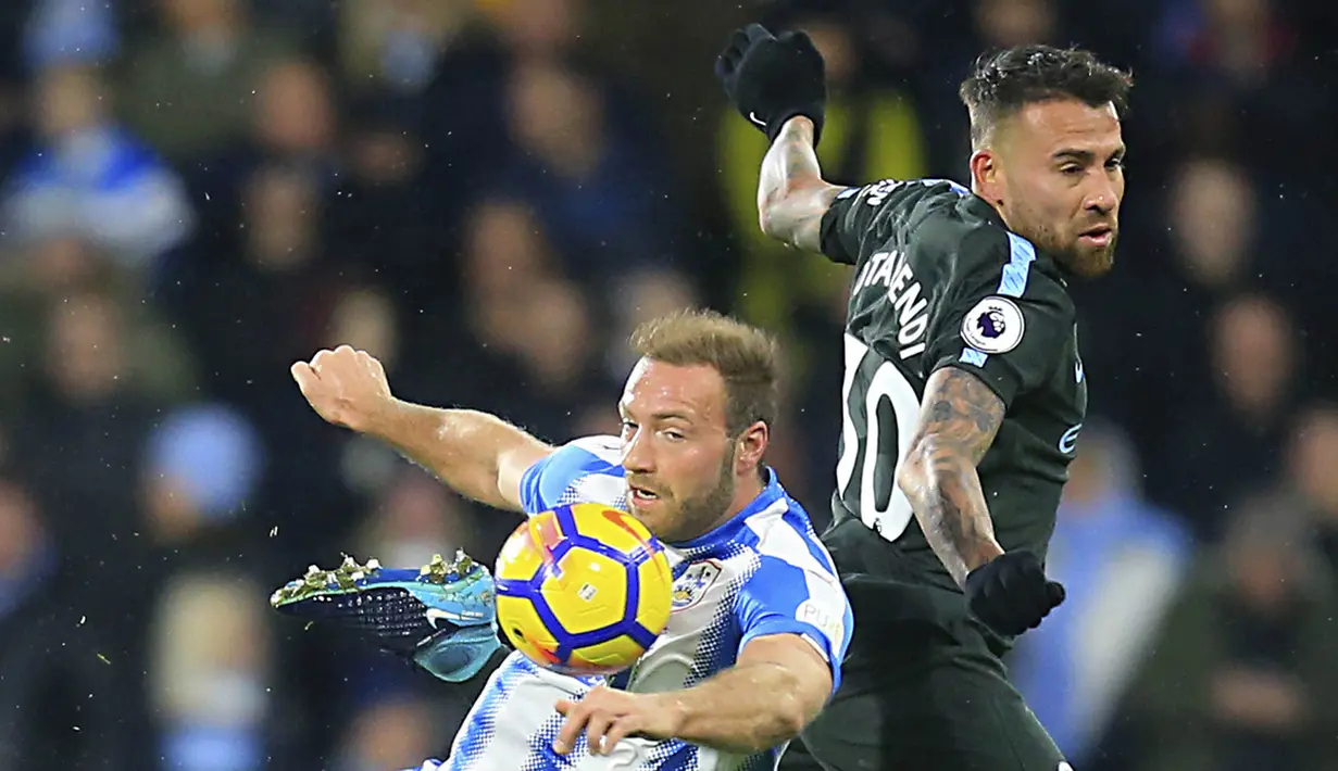 Striker Huddersfield, Laurent Depoitre, berebut bola dengan bek Manchester City, Nicolas Otamendi, pada laga Premier League di Stadion John Smith, Huddersfield, Minggu (26/11/2017). Huddersfield kalah 1-2 dari City. (AP/Danny Lawson)
