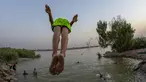 Seorang pemuda terjun ke Sungai Shatt Al-Arab di Kota Basra, Irak, Selasa (9/6/2020). Sungai yang memiliki panjang sekitar 200 Km ini menandai perbatasan antara Irak dan Iran. (Hussein FALEH/AFP)