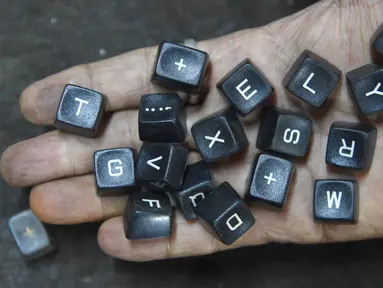 Pekerja menunjukan tombol mesin tik tua di bengkelnya di Mumbai, India (6/7). Walaupun dunia barat sudah meninggalkan, India membuktikan telah menjadi basis terakhir pertahanan penggunaan mesin ketik. (AFP Photo/Indranil Mukherjee)