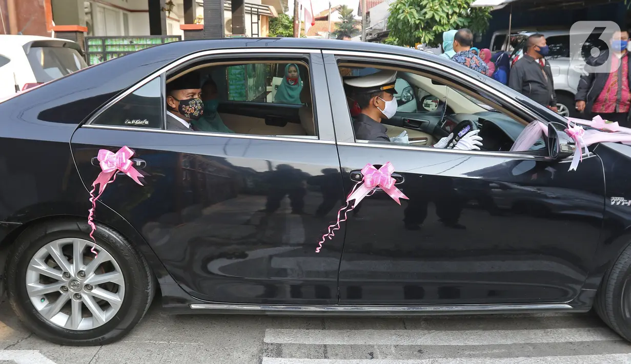 Pengantin menggunakan mobil dinas Pemkot Bekasi menuju lokasi pernikahan di Bekasi, Jawa Barat, Sabtu (12/9/2020). Wakil Wali Kota Bekasi menyediakan fasilitas gratis mobil dinas pada hari Sabtu dan Minggu untuk antar jemput pengantin saat pandemi COVID-19. (Liputan6.com/Herman Zakharia)