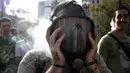 Seorang pria mengisap ganja menggunakan masker di alun-alun Plaza de Mayo selama pawai dunia untuk undang-undang mariyuana di Buenos Aires, Argentian (6/5).(AFP Photo/Juan Mabromata)