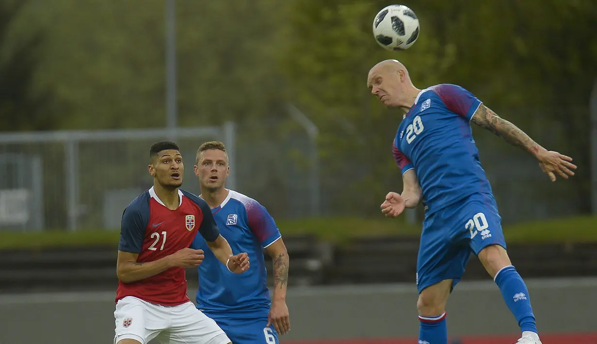 Pemain Islandia, Emil Hallfredsson (kanan) menghalau bola dari kejaran pemain Norwegia pada laga uji coba di Reykjavik, Islandia, (2/6/2018). Islandia kalah dari Norwegia 2-3. (AFP/Haraldur Gudjonsson)