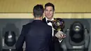 Lionel Messi (kanan) menerima ucapan selamat dari rivalnya Cristiano Ronaldo usai menerima penghargaan Balllon d'Or di Kongresshaus, Zurich, Selasa (11/1/2016).  (AFP Photo/Fabrice Coffrini)