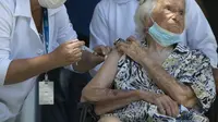 Zelia de Carvalho Morley, nenek berusia 106 tahun penyintas Flu Spanyol menerima suntikan vaksin COVID-19 CoronaVac, buatan Sinovac, di Rio de Janeiro, Brazil (20/1/2021). (Photo credit: AP Photo/Bruna Prado)