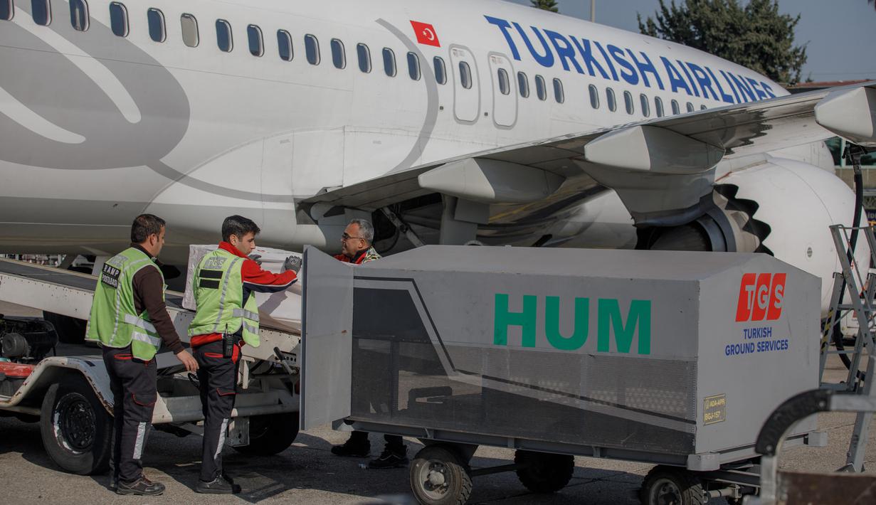Peti mati berisi jenazah mantan pemain sepak bola internasional Ghana Christian Atsu dimuat ke pesawat menuju Ghana, di bandara Adana di selatan Turki, 18 Februari 2023. Mantan pemain internasional Ghana Christian Atsu ditemukan tewas pada 18 Februari, hampir dua minggu setelah gempa dahsyat di Turki. (AFP/Can Erok)
