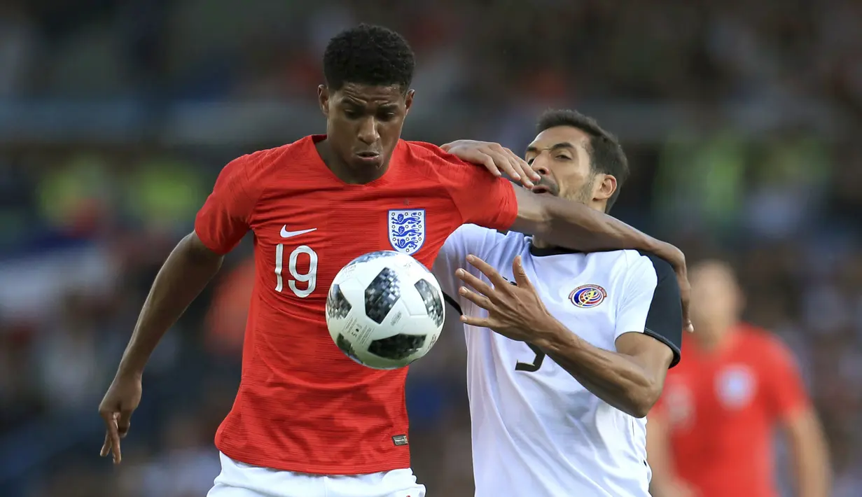 Pemain Inggris, Rashford (kiri) berusaha melewati pemain Kosta Rika, Celso Borges pada laga uji coba di Elland Road Stdium, Leeds, Inggris, (7/6/2018). Inggris menang 2-0. (Mike Egerton/PA via AP)