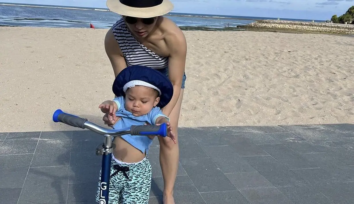 Nikita Willy tampil dengan one shoulder bergaris dipadukan short pants denim dan topi pantainya. @nikitawillyofficial94