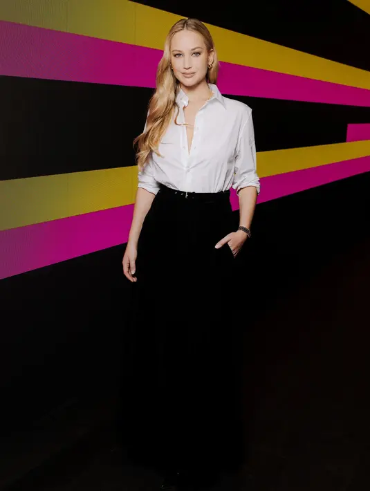 Jennifer Lawrence mengenakan kemeja katun putih Dior Cruise 2024 dengan rok beludru hitam. [Dior]
