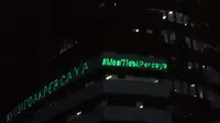 Aktivis Greenpeace menembakkan sinar laser bertuliskan Mosi Tidak Percaya ke gedung Merah Putih KPK, Jakarta, Senin (28/6/2021) malam. Aksi tersebut sebagai bentuk keprihatinan atas upaya pelemahan KPK sejak disahkannya Revisi UU KPK hingga Tes Wawasan Kebangsaan. (Liputan6.com/Helmi Fithriansyah)