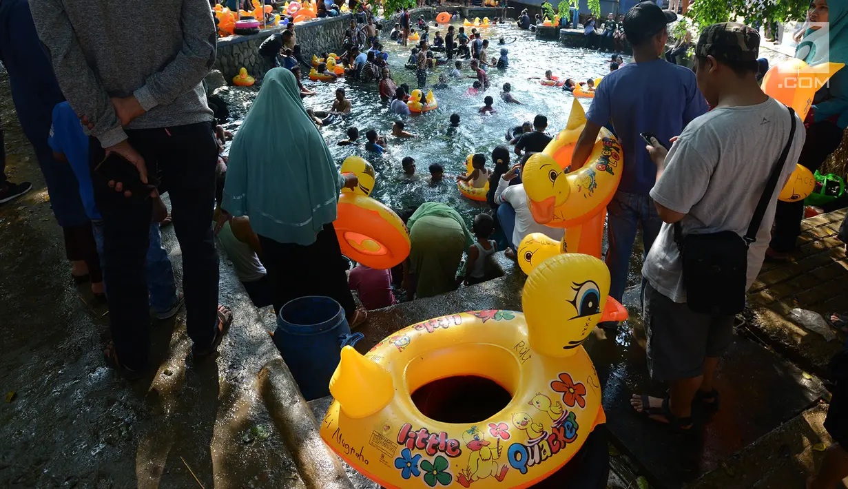 Warga bermain air di wisata alam Mata Air Sodong di Desa Ligar Mukti, Klapanunggal, Kabupaten Bogor, Jawa Barat, Minggu (9/6). Pengunjung hanya dikenakan Rp 10.000 untuk motor dan mobil Rp 20.000 di tempat wisata ini. (merdeka.com/Imam Buhori)