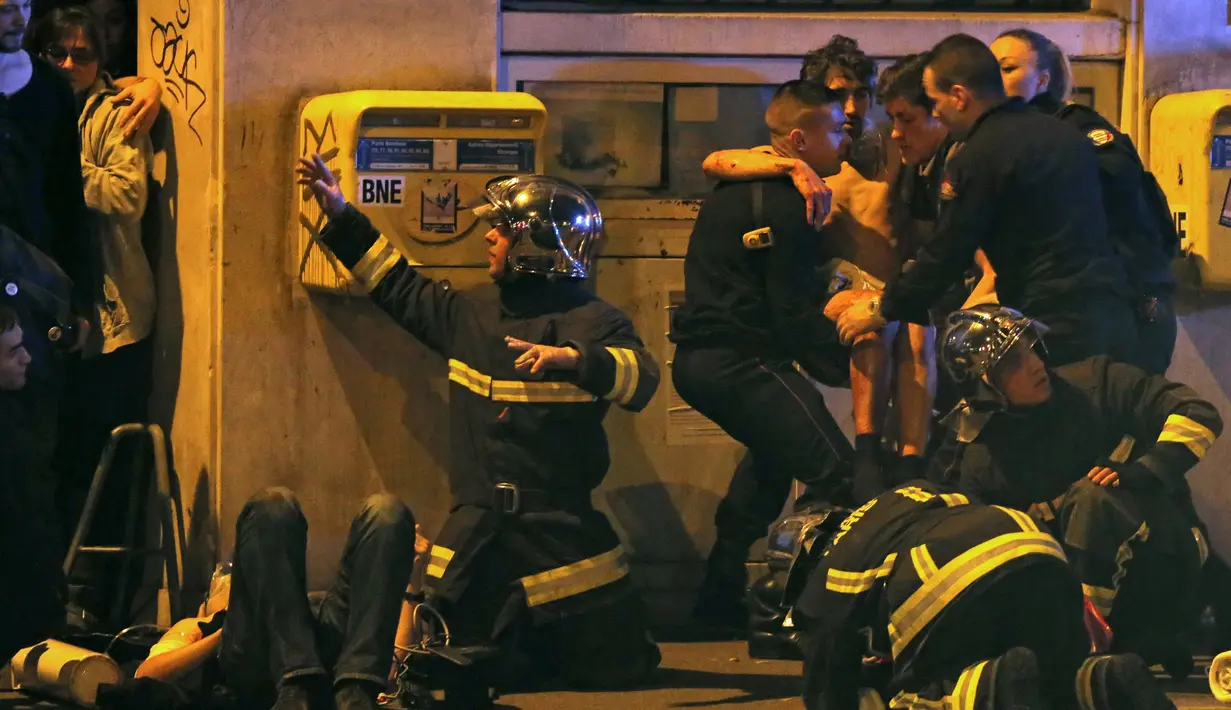 Korban yang terluka mendapat pertolongan dari petugas usai aksi penembakan dan bom bunuh diri yang dilakukan teroris di Paris, Perancis, Jumat (13/11/2015). Dikabarkan ada 140 orang tewas dalam aksi teroris tersebut. (Reuters)