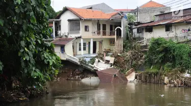 Kondisi bangunan rumah yang amblas akibat longsor di bantaran Kali Ciliwung, Kelurahan Bidara Cina, Jakarta Timur, Senin (19/3). Tak ada korban jiwa atau luka dalam musibah yang terjadi pada Minggu dini hari tersebut. (Liputan6.com/Herman Zakharia)