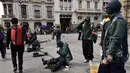 Para tukang semir sepatu bertopeng menunggu pelanggan di kawasan La Paz, Bolivia (29/11). Karena diantara mereka masih ada yang menjalani pendidikan di sekolah dan universitas para tukang semir ini menutup wajahnya. (AFP PHOTO/Aizar Raldes)