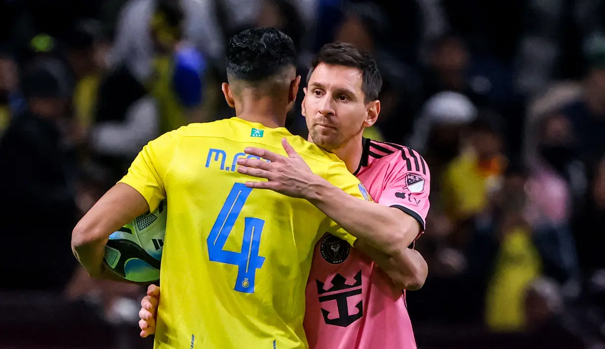 Pemain Inter Miami, Lionel Messi (kanan) berpelukan dengan pemain Al-Nassr, Mohammed al-Fatil setelah laga persahabatan di Kingdom Arena Stadium, Riyadh, Arab Saudi, Jumat (02/02/2024) dini hari WIB. Ronaldo absen pada laga ini akibat cedera. (AFP)