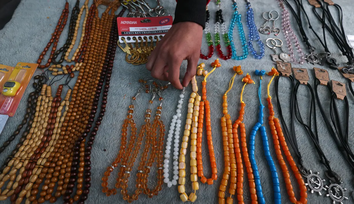 Seorang pedagang Palestina menata tasbih di kiosnya di pasar selama bulan suci Ramadhan di kota Rafah, Jalur Gaza selatan, pada 10 April 2022. (SAID KHATIB / AFP)