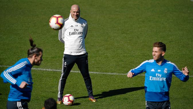 Pelatih Real Madrid Zinedine Zidane melihat kiper Luca Zidane dan Gareth Bale berlatih di fasilitas pelatihan Valdebebas di Madrid (15/3). Real Madrid akan bertanding melawan Celta Vigo pada lanjutan La Liga Spanyol. (AFP Photo/Gabriel Bouys)