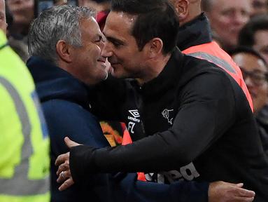Pelatih Derby County, Frank Lampard, berpelukan dengan pelatih Manchester United, Jose Mourinho, pada Piala Liga Inggris di Stadion Old Trafford, Rabu (26/9/2018). Manchester United takluk adu penalti 9-10 (2-2) dari Derby County. (AFP/Paul Ellis)