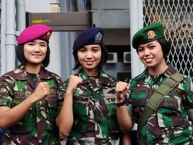 Tiga prajurit wanita TNI berpose di depan gerbang masuk Stadion GBK Jakarta, Minggu (24/1/2016). TNI mengerahkan prajurit wanita untuk memberi rasa aman dan nyaman bagi para suporter perempuan. (Liputan6.com/Helmi Fithriansyah)