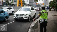 Petugas Polantas mengantur lalu lintas di kawasan Thamrin, Jakarta, Rabu (25/7). Kebijakan pembatasan kendaraan dengan penerapan pelat ganjil genap dimulai pada 27 Juli mendatang. (Liputan6.com/Faizal Fanani)