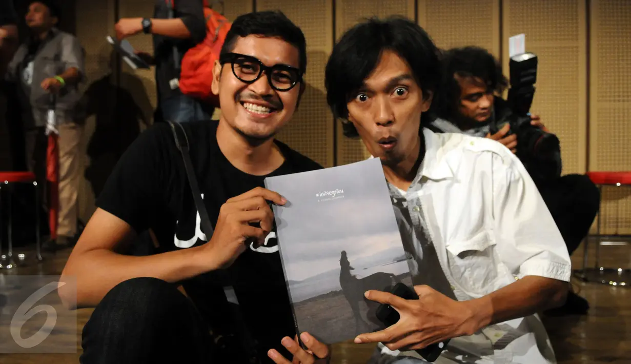 Pewarta foto Forbes Indonesia, Ahmad Zamroni (kanan) menunjukkan buku karya para pewarta foto yang tergabung dalam 1000 kata saat bincang buku #iniNegriku di Galeri Indonesia Kaya, Jakarta, Rabu (13/1/2016). (Liputan6.com/Helmi Fithriansyah)