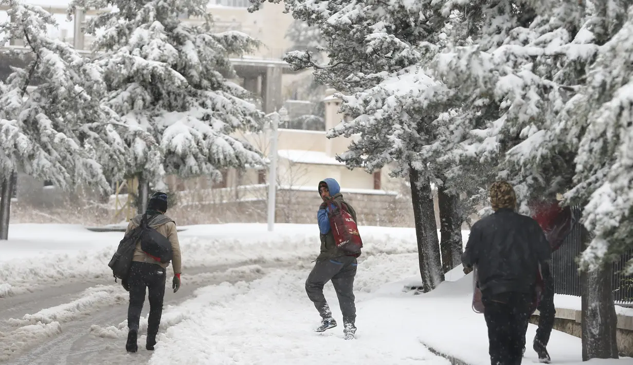 Pekerja Suriah berjalan di tengah salju di Aley, Lebanon, Jumat (1/12/2016). Badai salju di Lebanon menambah kesengsaraan puluhan ribu pengungsi Suriah yang tinggal di tempat penampungan sementara wilayah tersebut. (REUTERS/Jamal Saidi)
