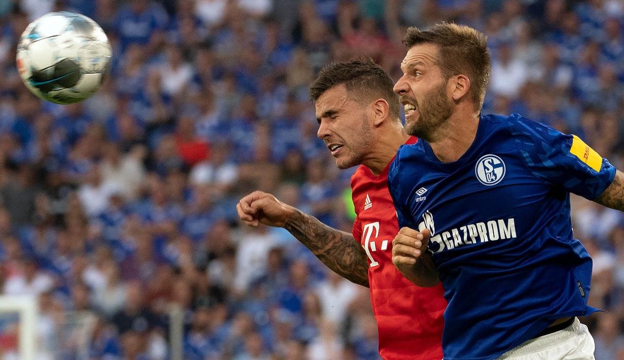 Bek Bayern Munchen, Lucas Hernandez, duel udara dengan striker Schalke, Guido Burgstaller, pada laga Bundesliga di Veltins-Arena, Gelsenkirchen, Sabtu (24/8). Schalke kalah 0-3 dari Munchen. (AFP/Federico Gabarini)