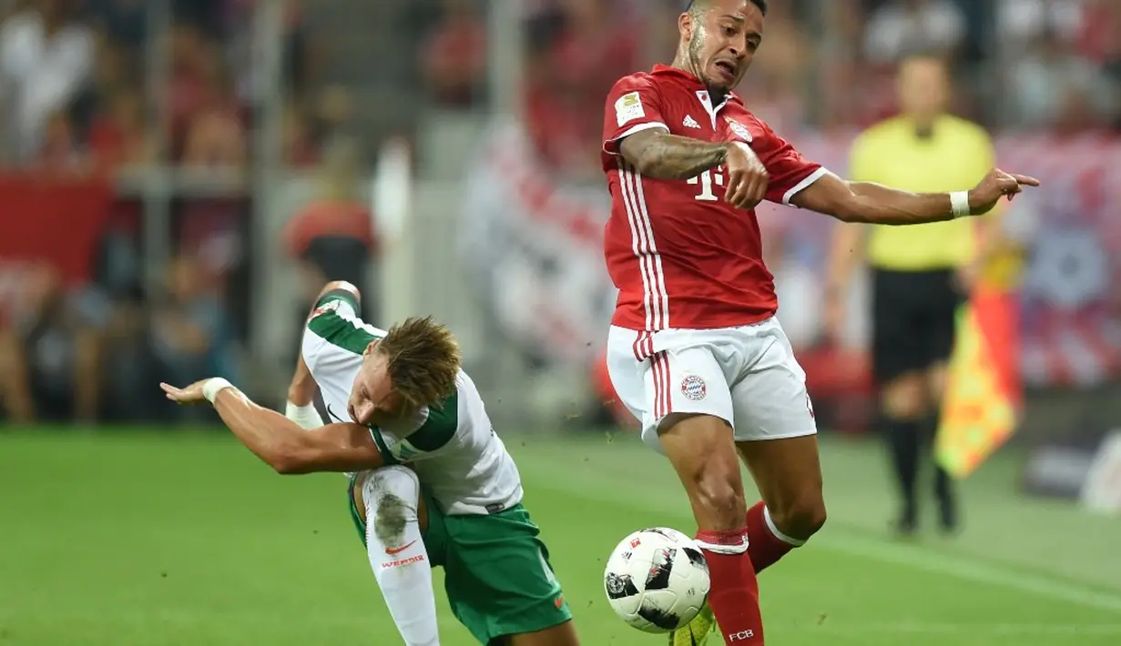 Pemain Bayern Munchen, Thiago Alcantara (kanan), berebut bola dengan pemain Werder Bremen, Robert Bauer, dalam laga Bundesliga di Allianz Arena, Munchen, Sabtu (27/8/2016) dini hari WIB. (AFP/Christof Stache)